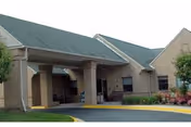 Exterior view of BrightHaven Home for Elderly entrance with covered driveway and landscaping.