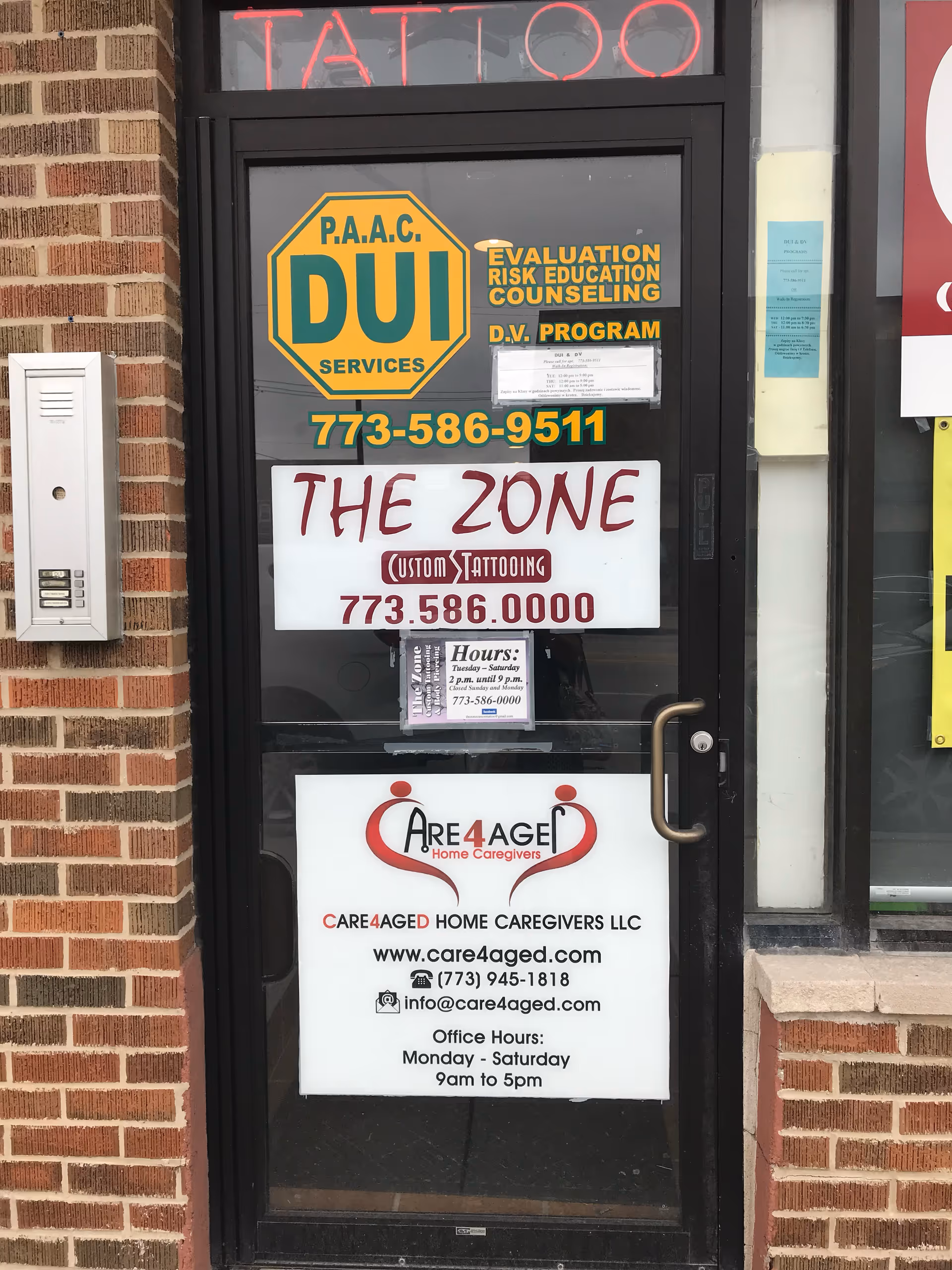 Front door of a brick building with multiple signs, including Care4Aged and a tattoo shop.