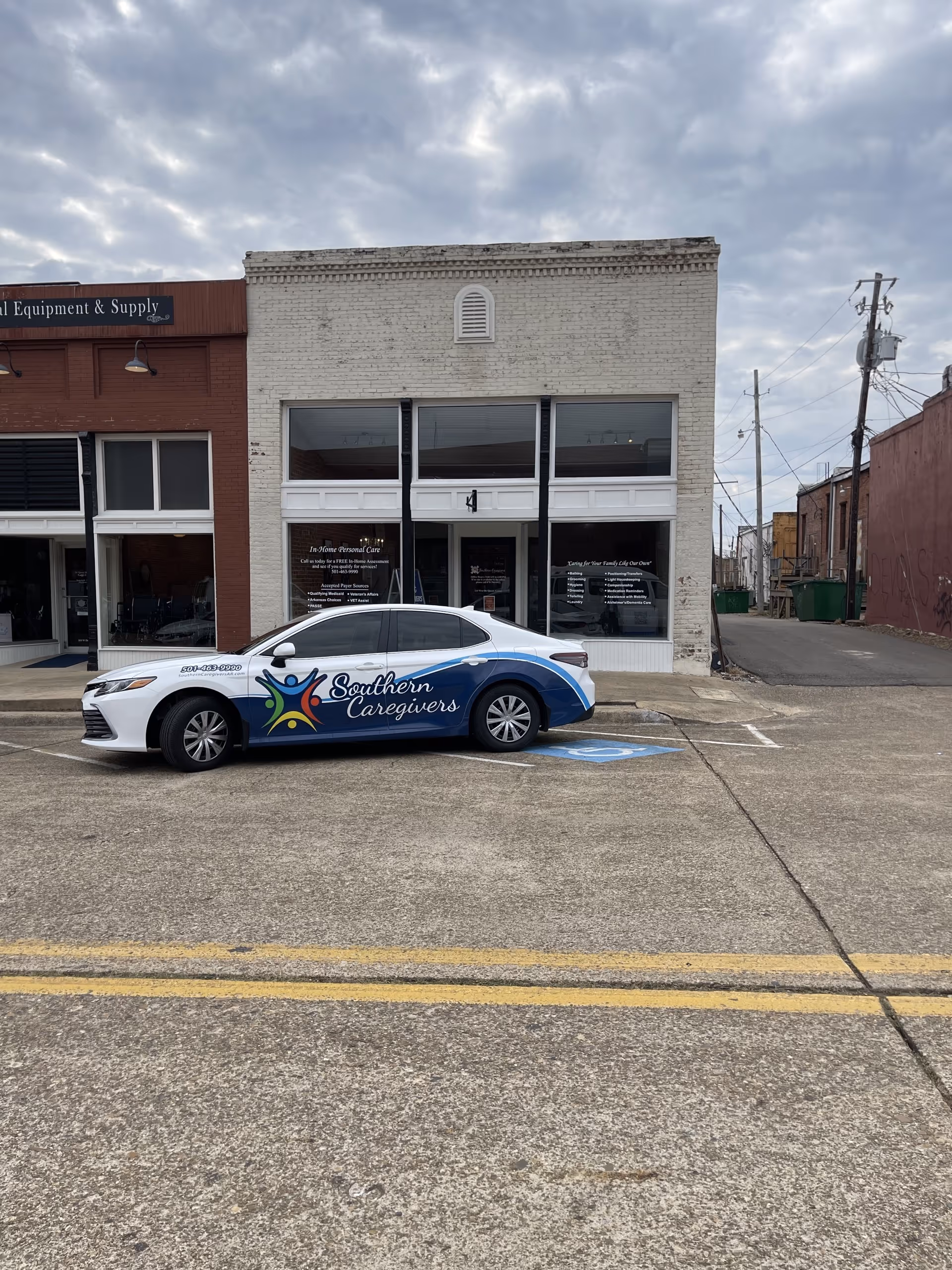 Street view of a storefront building with a parked car labeled Southern Caregivers.
