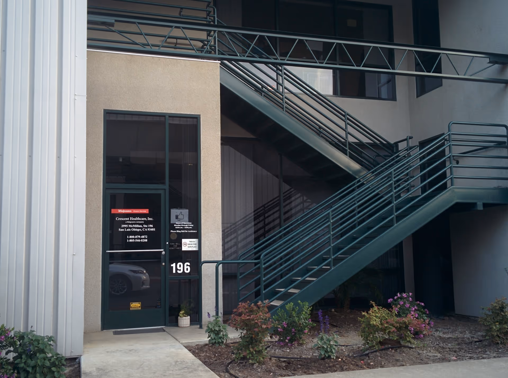 Exterior view of Crescent Healthcare entrance with a metal staircase and plants.