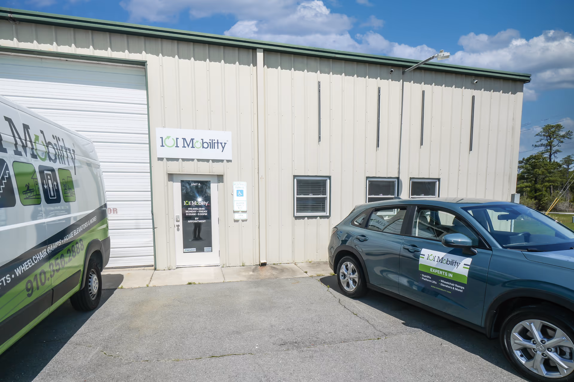 Exterior view of a beige building with 101 Mobility sign and two branded vans.