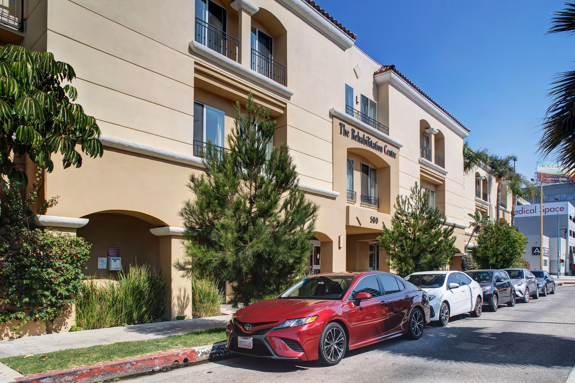 Exterior view of The Rehabilitation Centre of Beverly Hills with parked cars along the street.