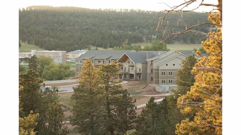 Exterior view of a Good Samaritan Society campus with multiple buildings amid trees and hills