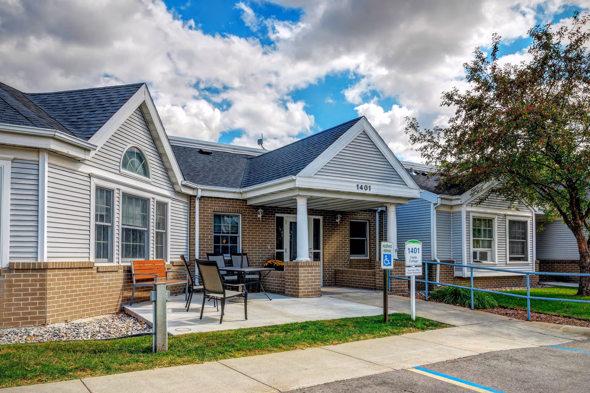 Exterior view of Ecumen Evergreens of Fargo front entrance with outdoor seating.