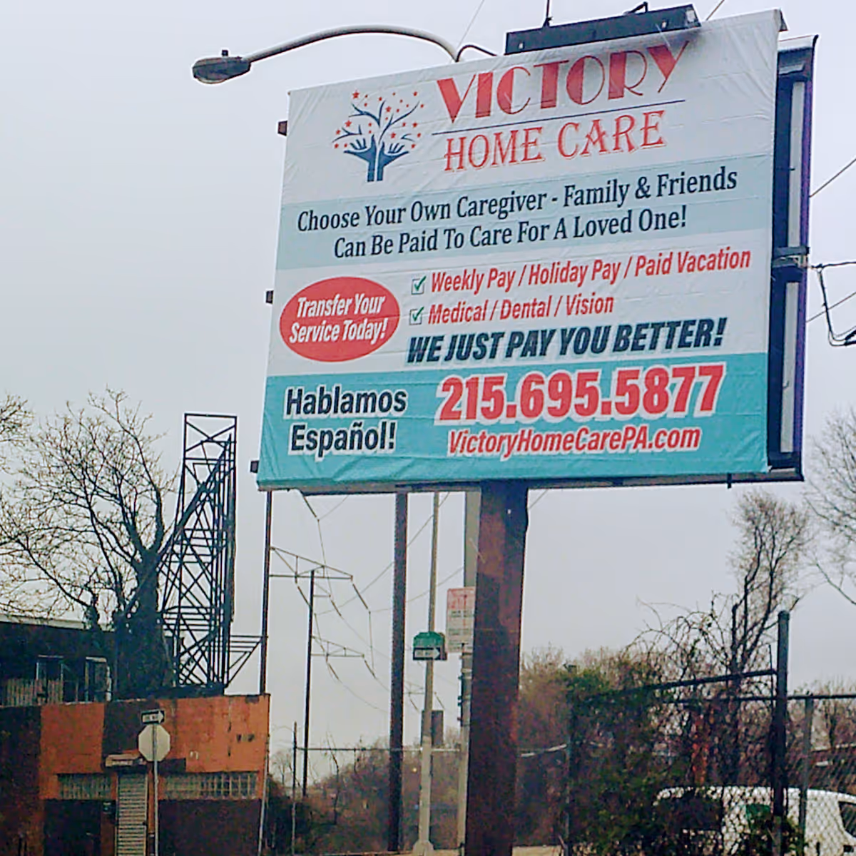 A large outdoor billboard advertising Victory Home Care Agency with contact details