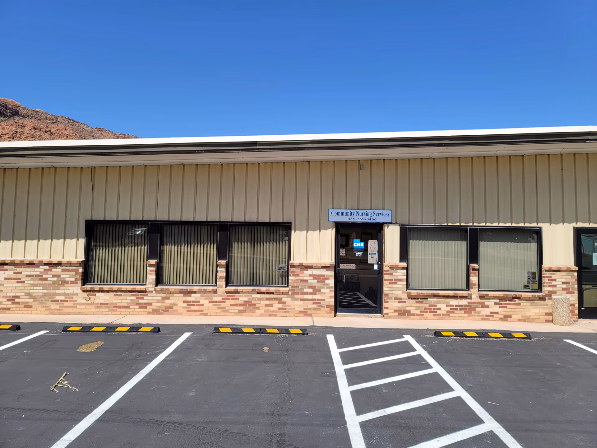Exterior view of a single-story facility with a sign reading Community Nursing Services in Moab.