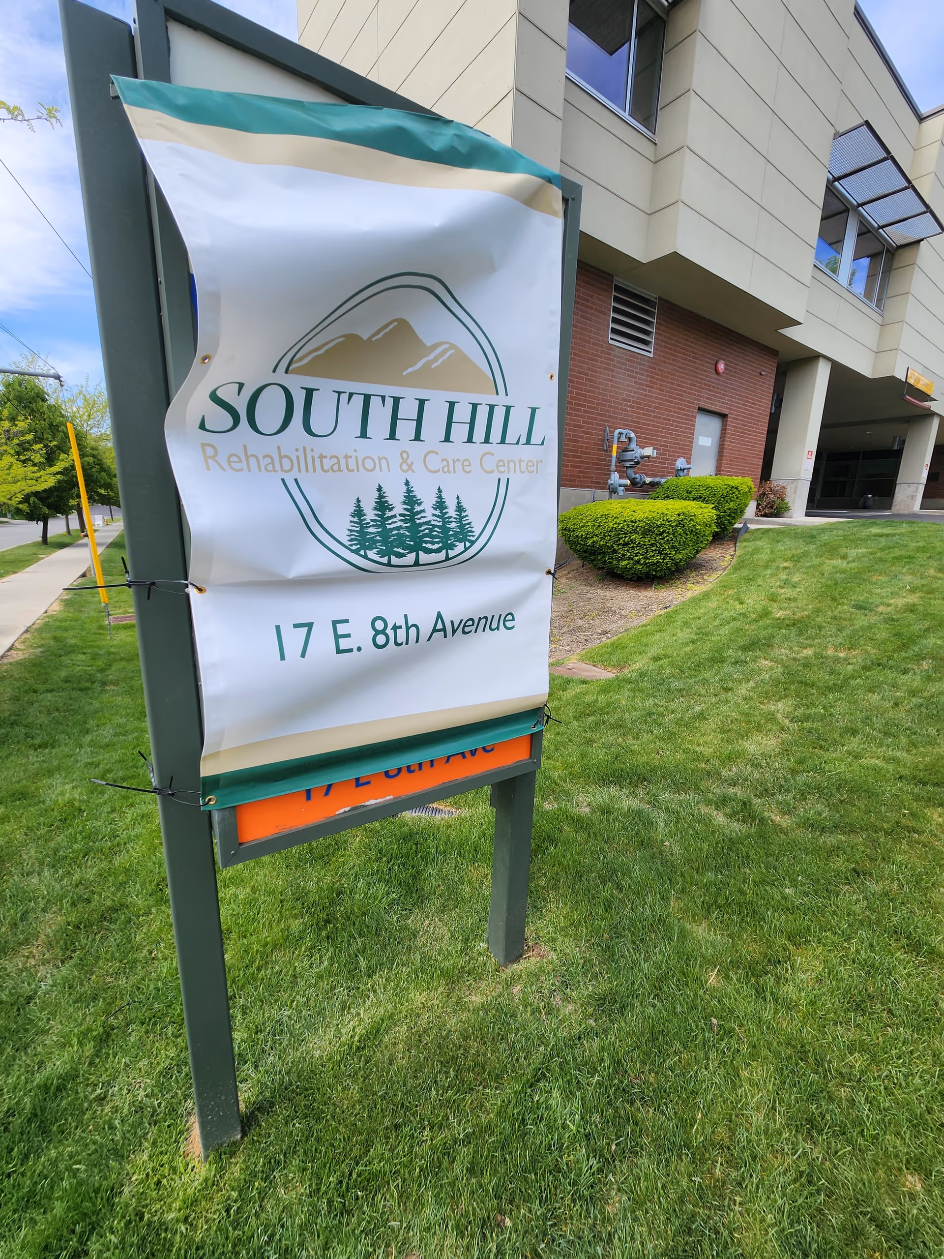 Exterior sign for South Hill Rehabilitation & Care Center in front of a modern building.