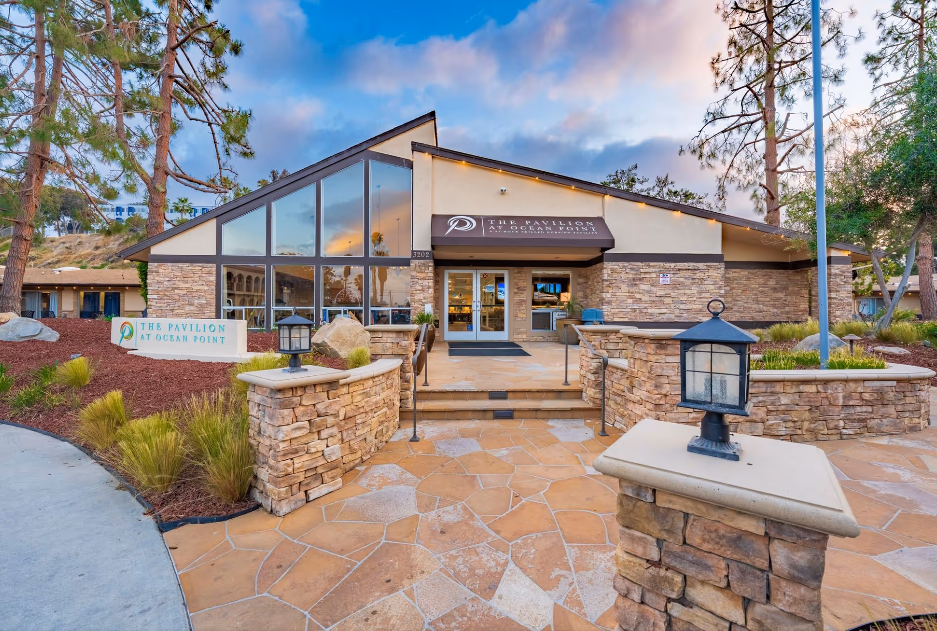 Exterior view of The Pavilion at Ocean Point with entrance, stone walls, and signage.