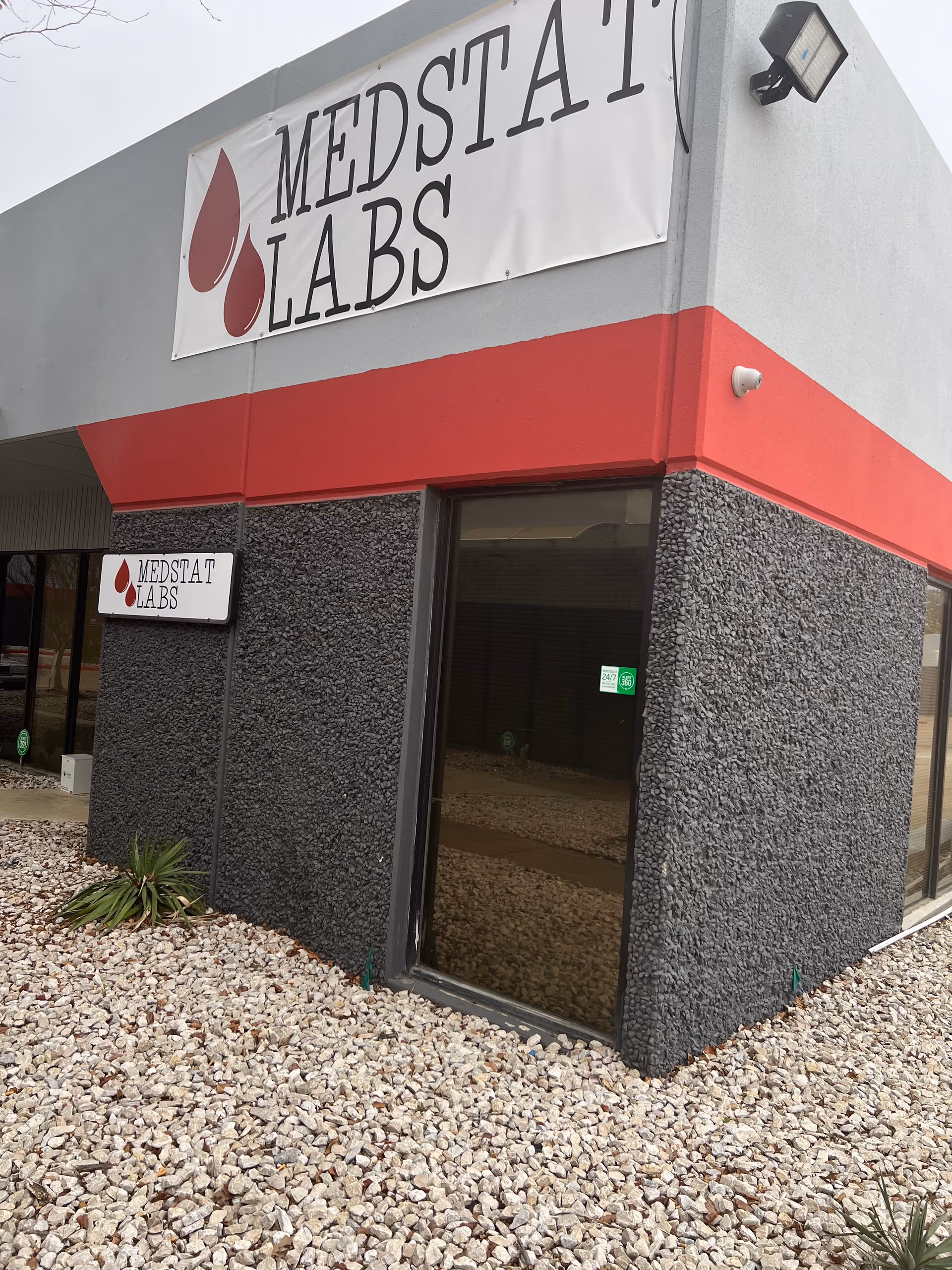 Exterior view of a gray building facade with a Medstat Labs sign.