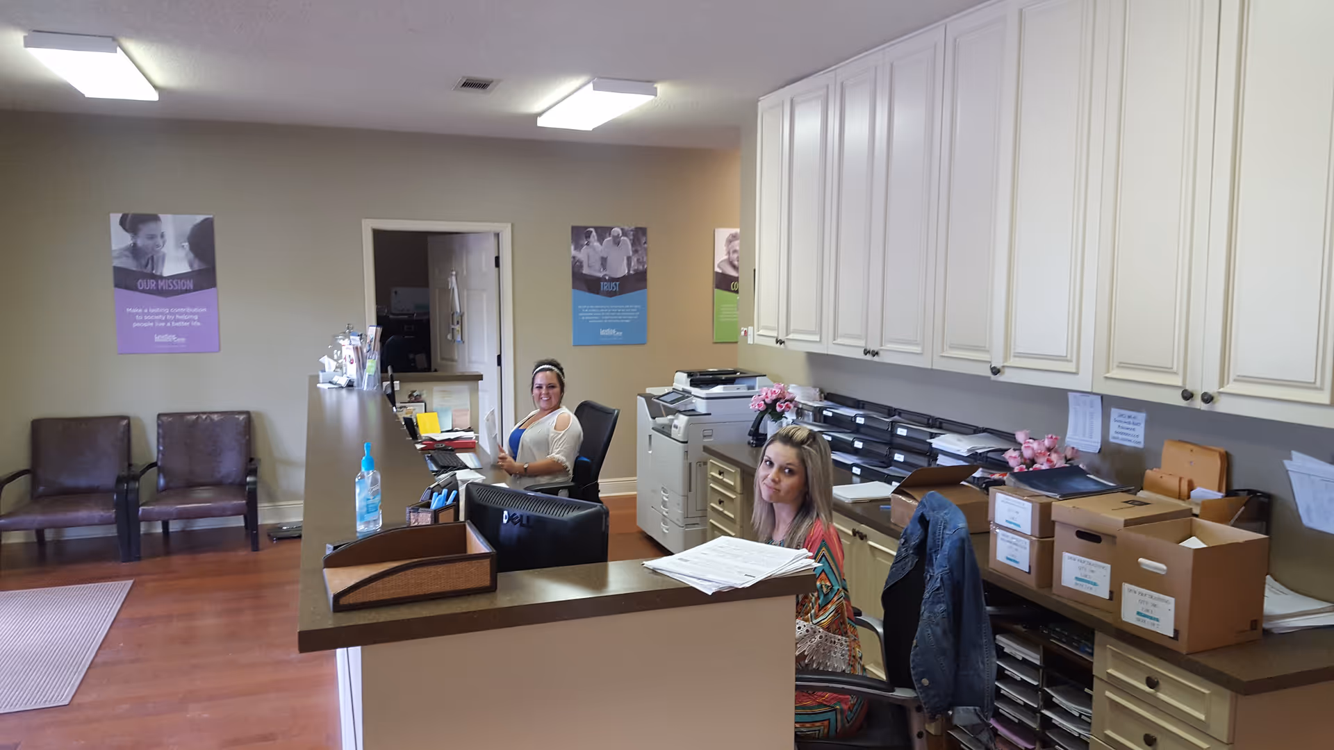 Reception area of Leading Home Care in Pineville featuring two staff at a front desk.