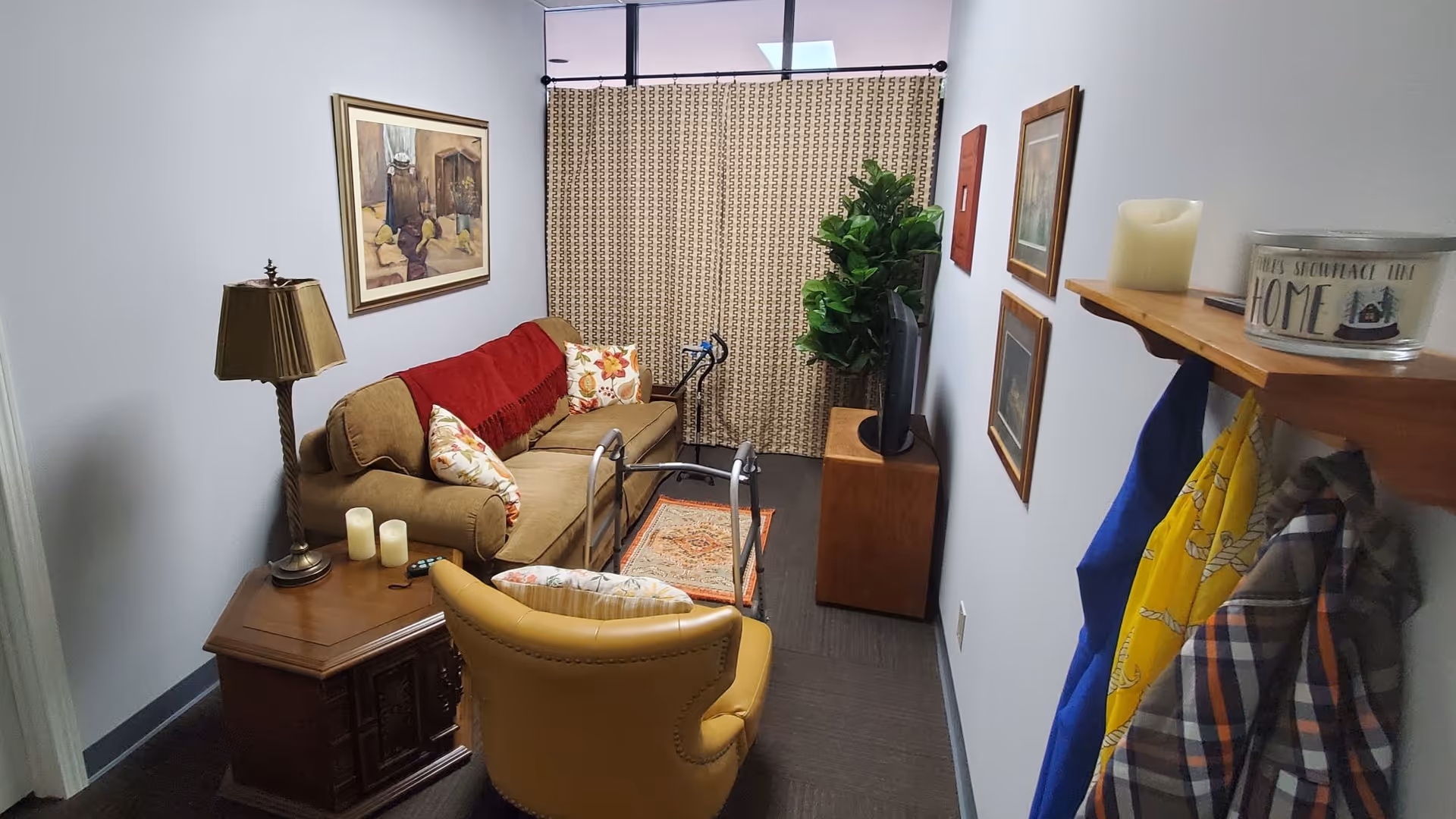 Cozy living room area with sofa, armchair, TV, and framed art.