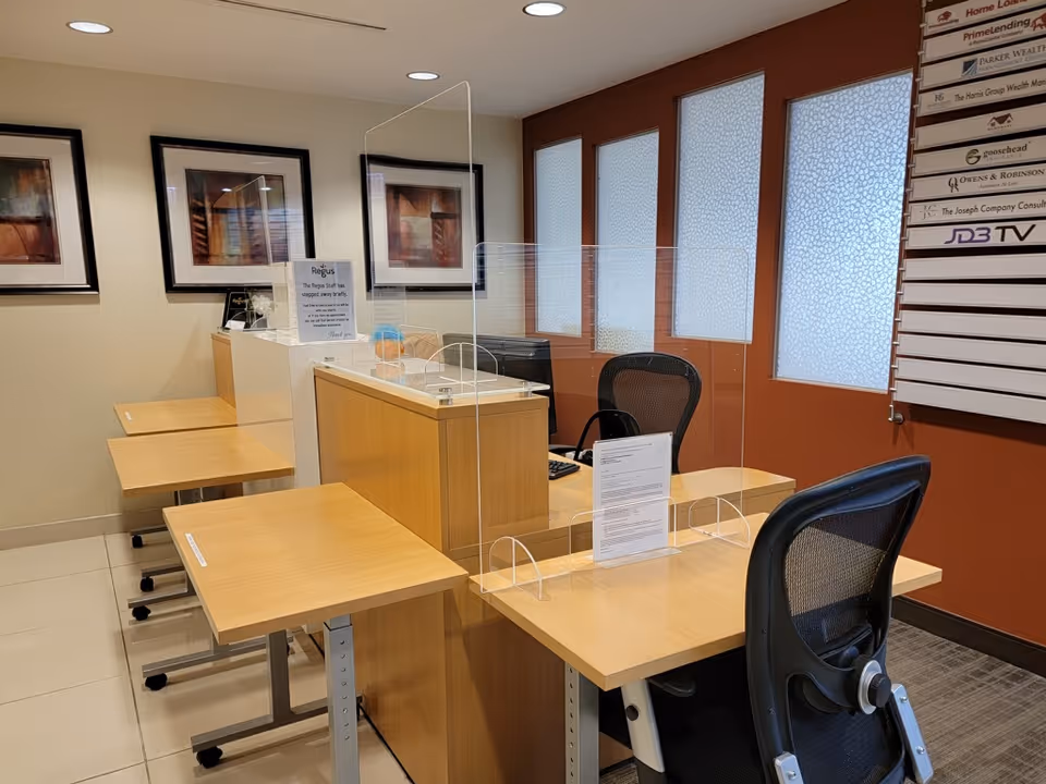 Reception area with partitioned desks, chairs, and frosted windows in a care facility.