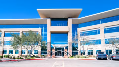 Modern senior living facility exterior with blue glass windows and central entrance.