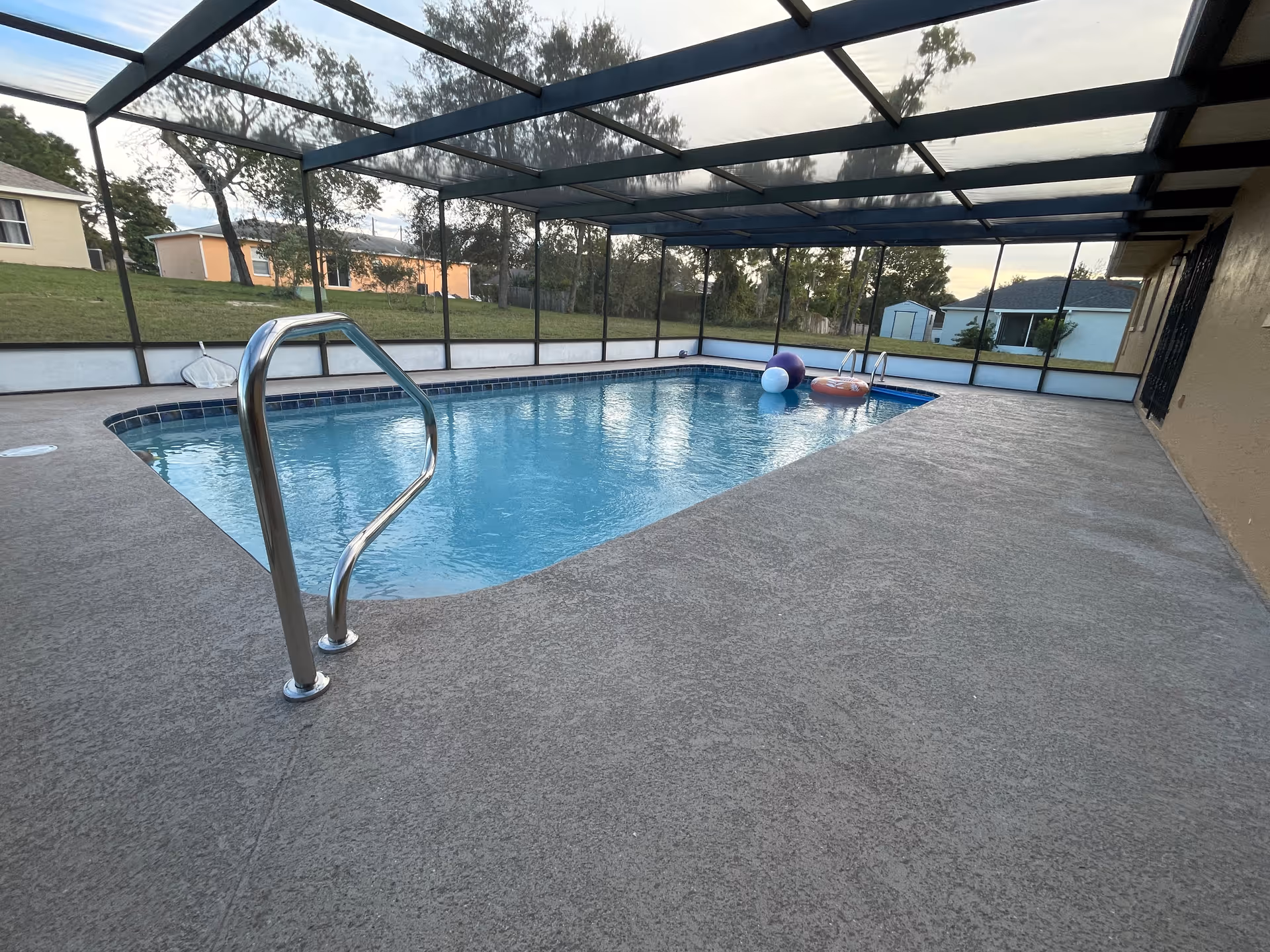 Enclosed outdoor pool area at The Best ALF with railing, toys, and enclosure.