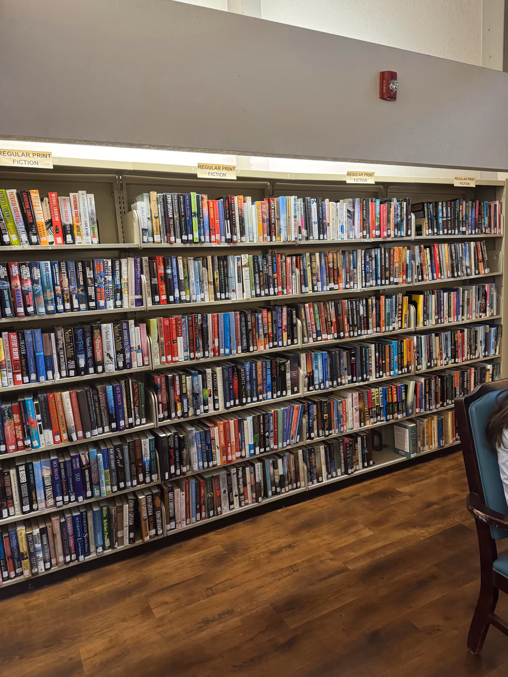 Rows of book-filled shelves line a library in the senior living facility.