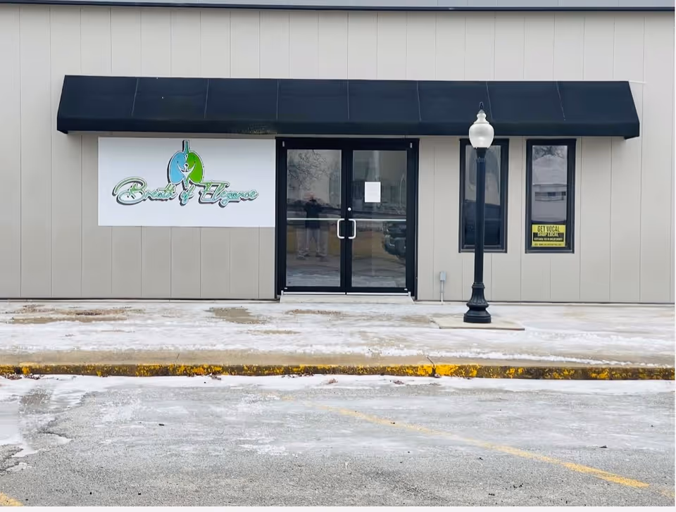 Exterior view of Breath of Elegance senior living facility entrance with a black awning.