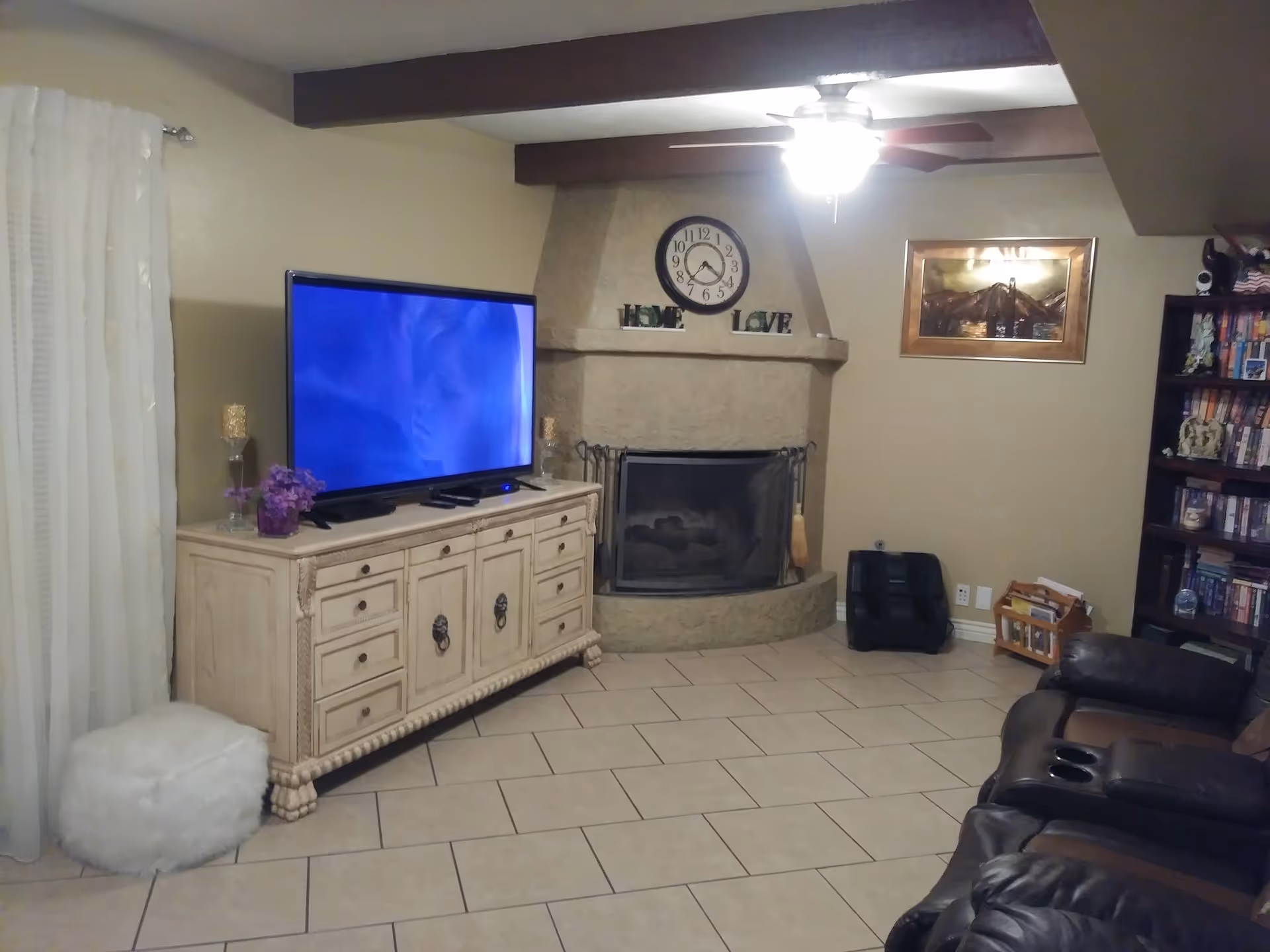 Cozy living room featuring a fireplace, TV, and leather seating.
