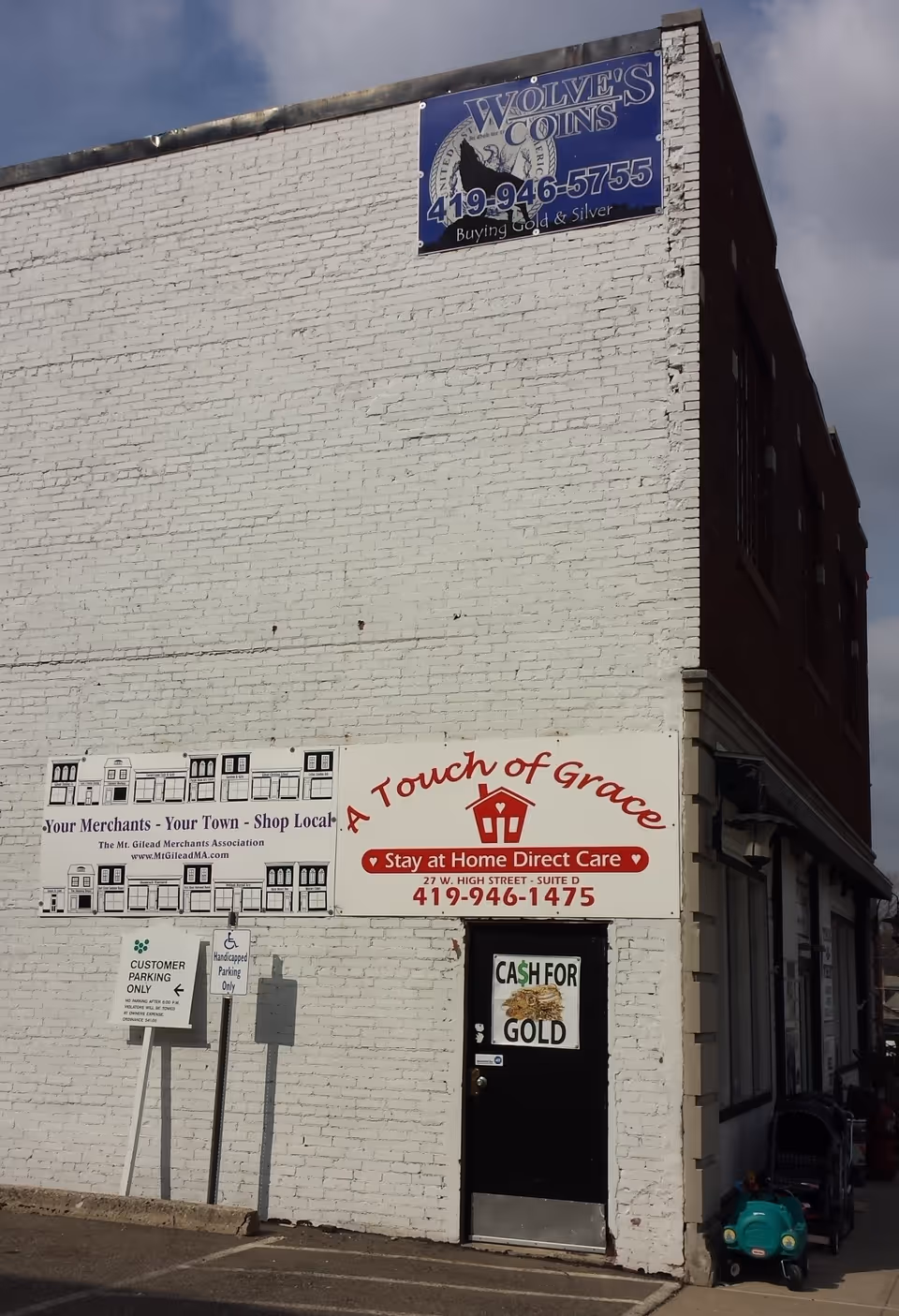 Exterior white brick building with A Touch of Grace storefront sign.