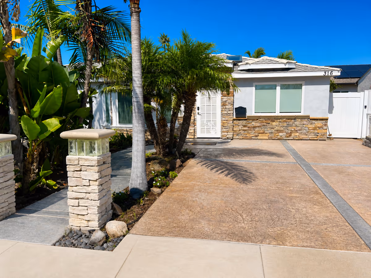 Front exterior of Boutique Care Senior Living, LLC with palm trees and stone façade.