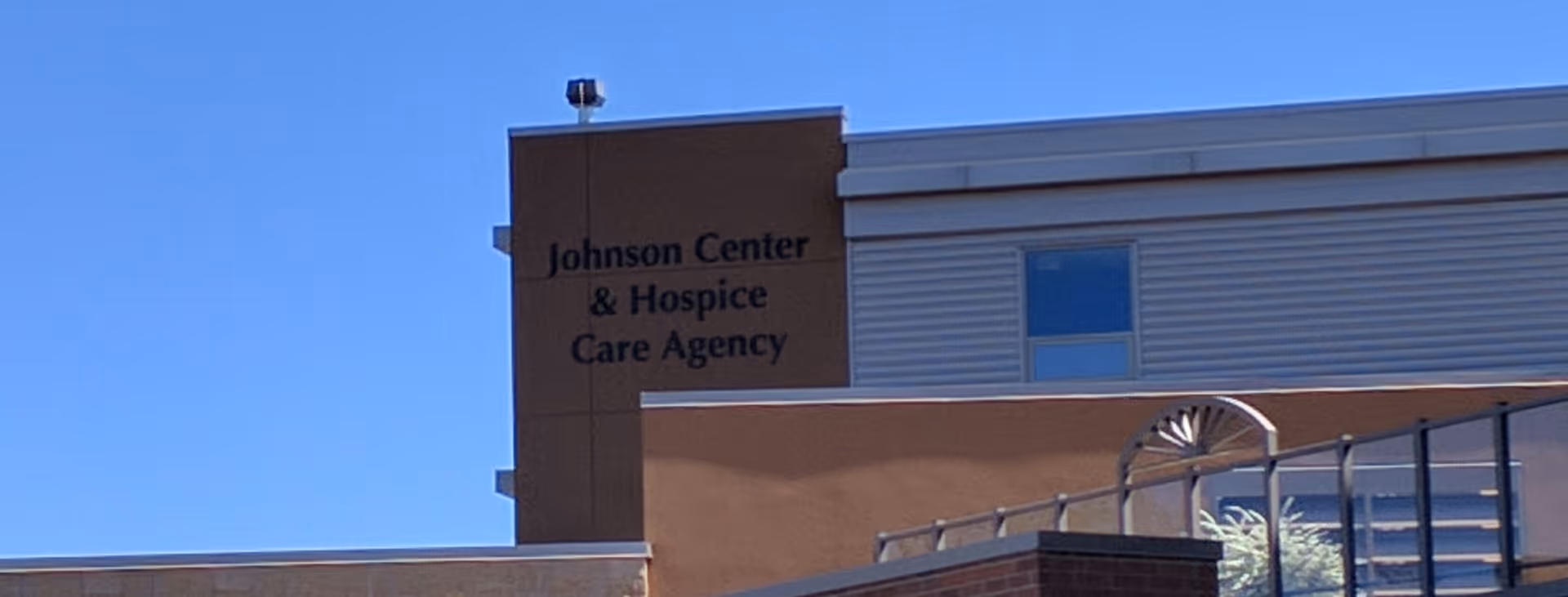 Part of a building exterior showing a sign that reads Johnson Center and Hospice Care Agency.