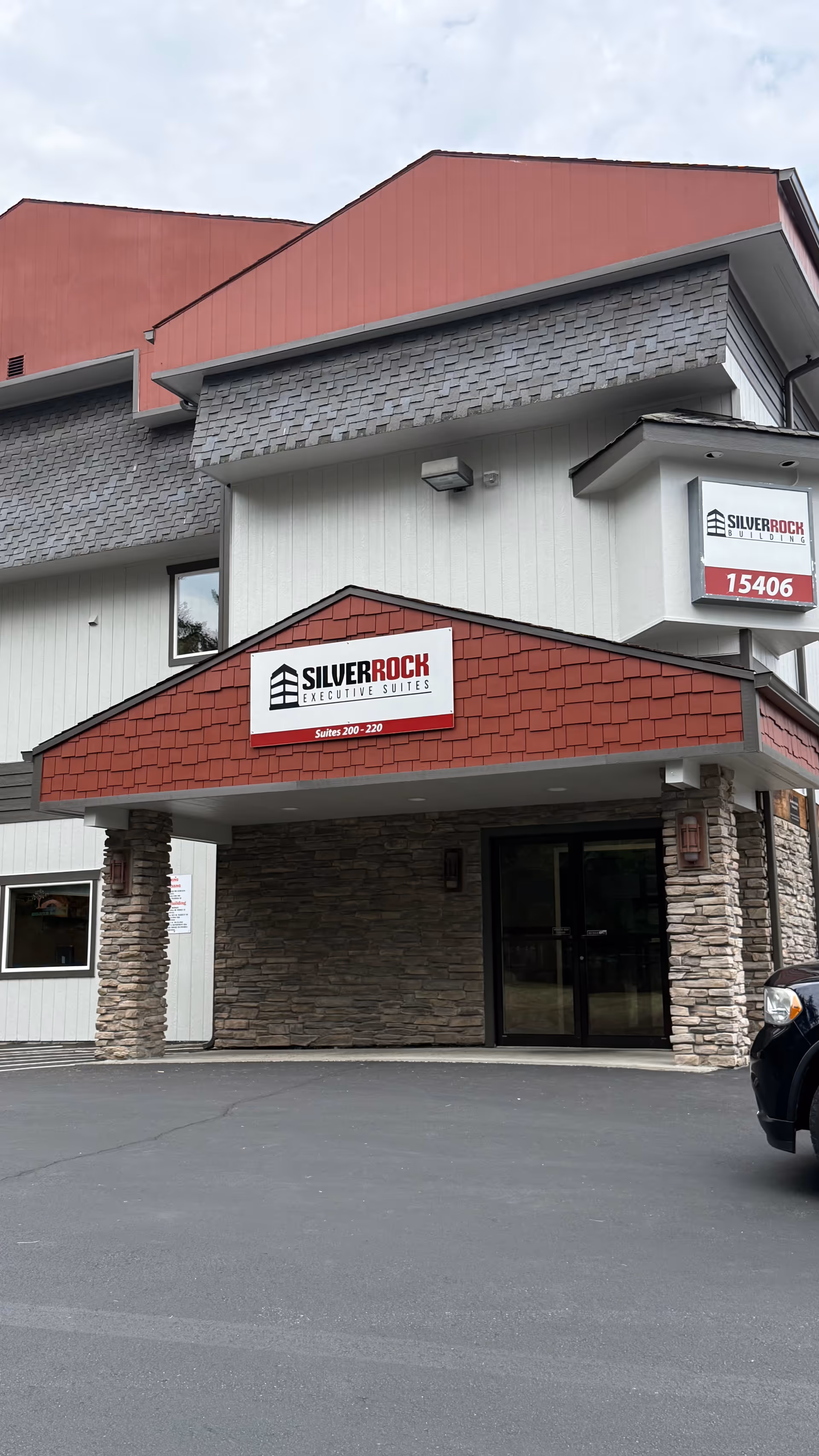 Exterior view of a building with stone pillars and red signage.