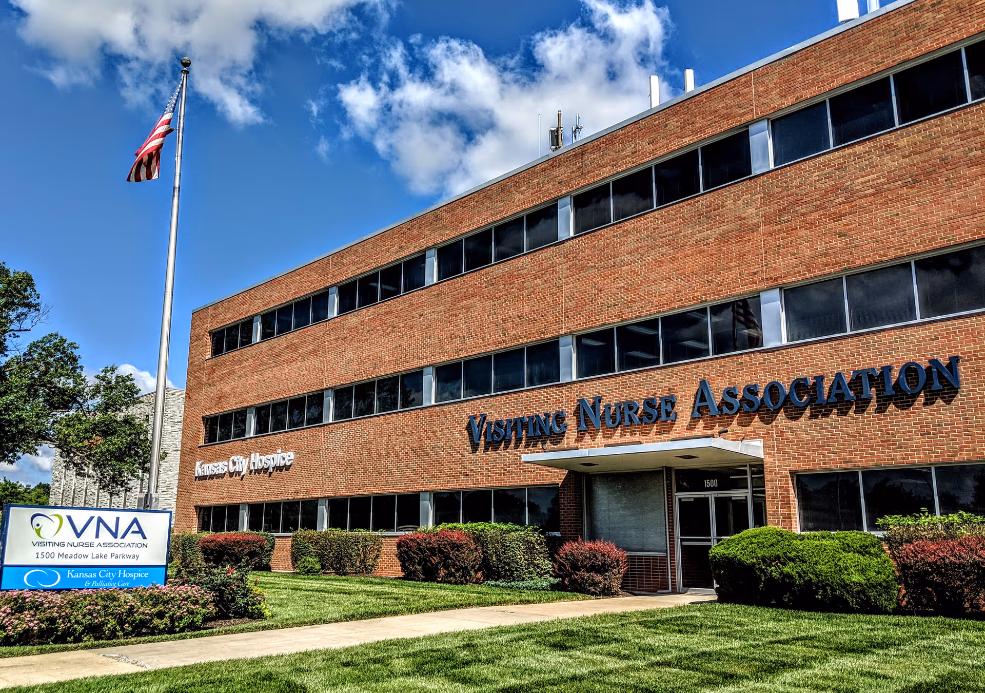 Three-story brick building with Kansas City Hospice and Visiting Nurse Association signs.