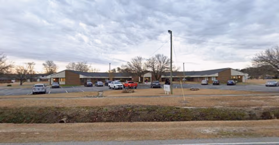 Exterior view of Highland Acres Nursing and Rehabilitation Center, a single-story brick facility with parking.