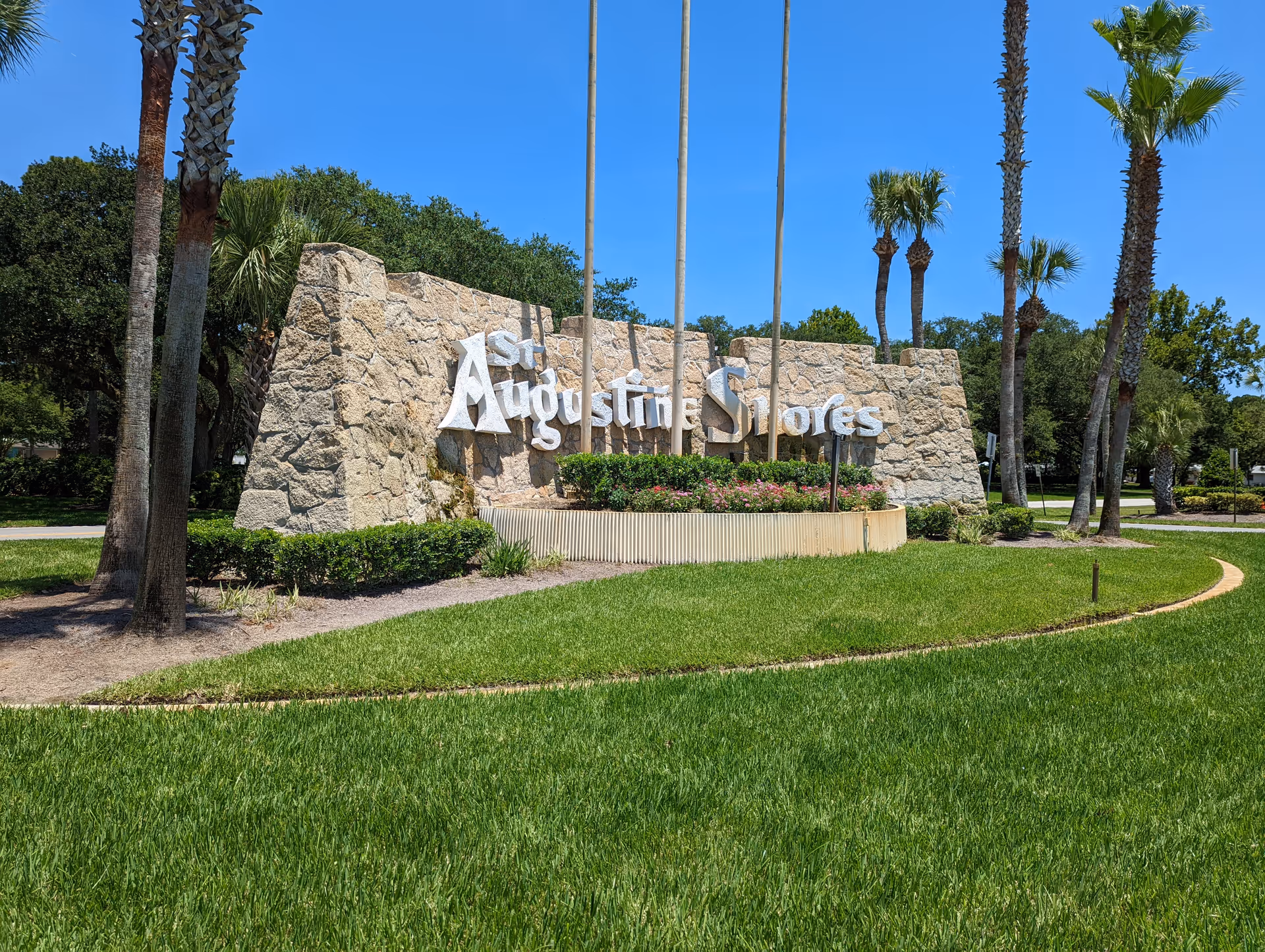 Stone entrance sign reading 'St Augustine Shores' with palm trees and green lawn