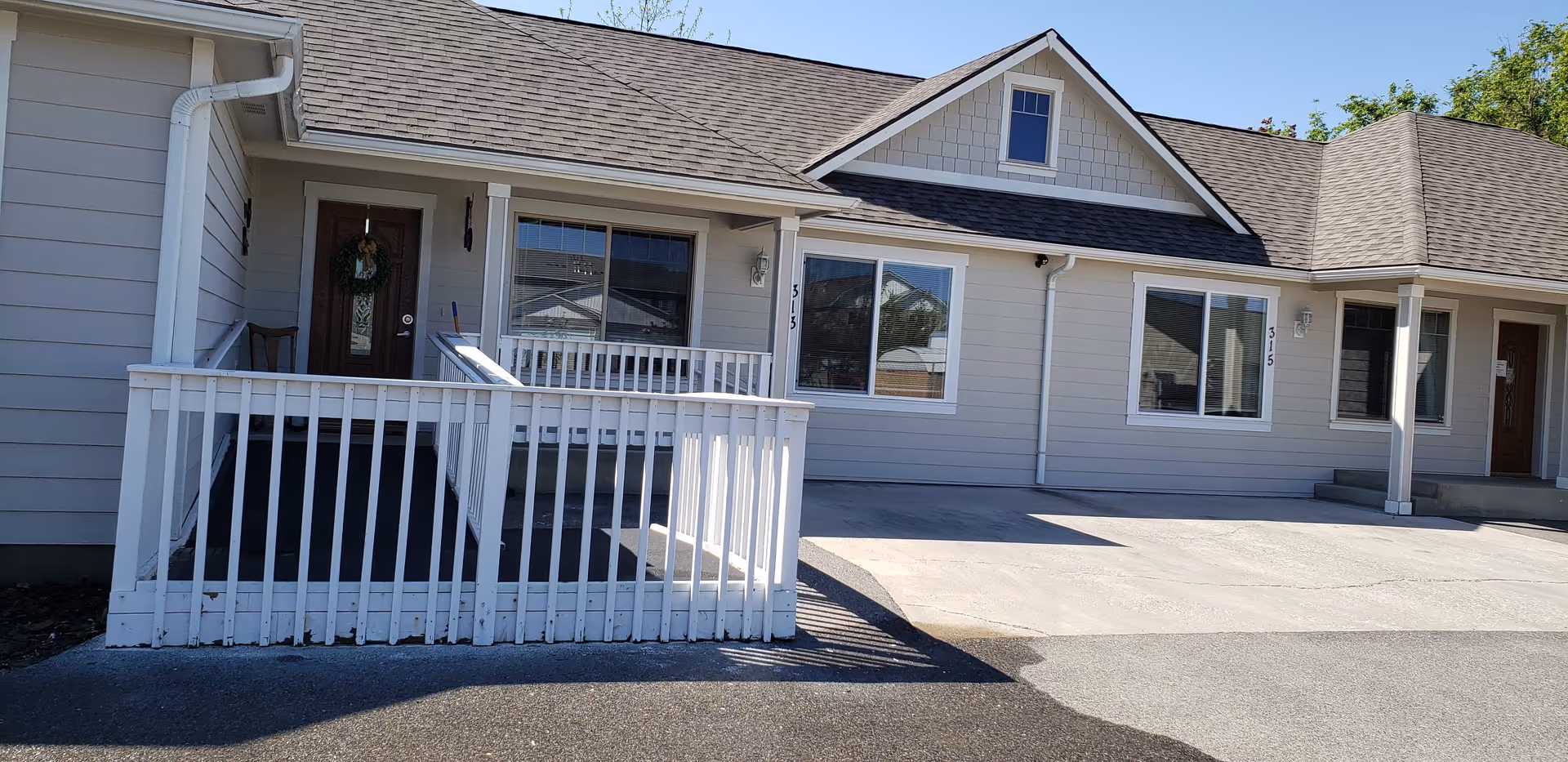 Single-story senior living facility exterior with white siding, porches, and multiple entrances.