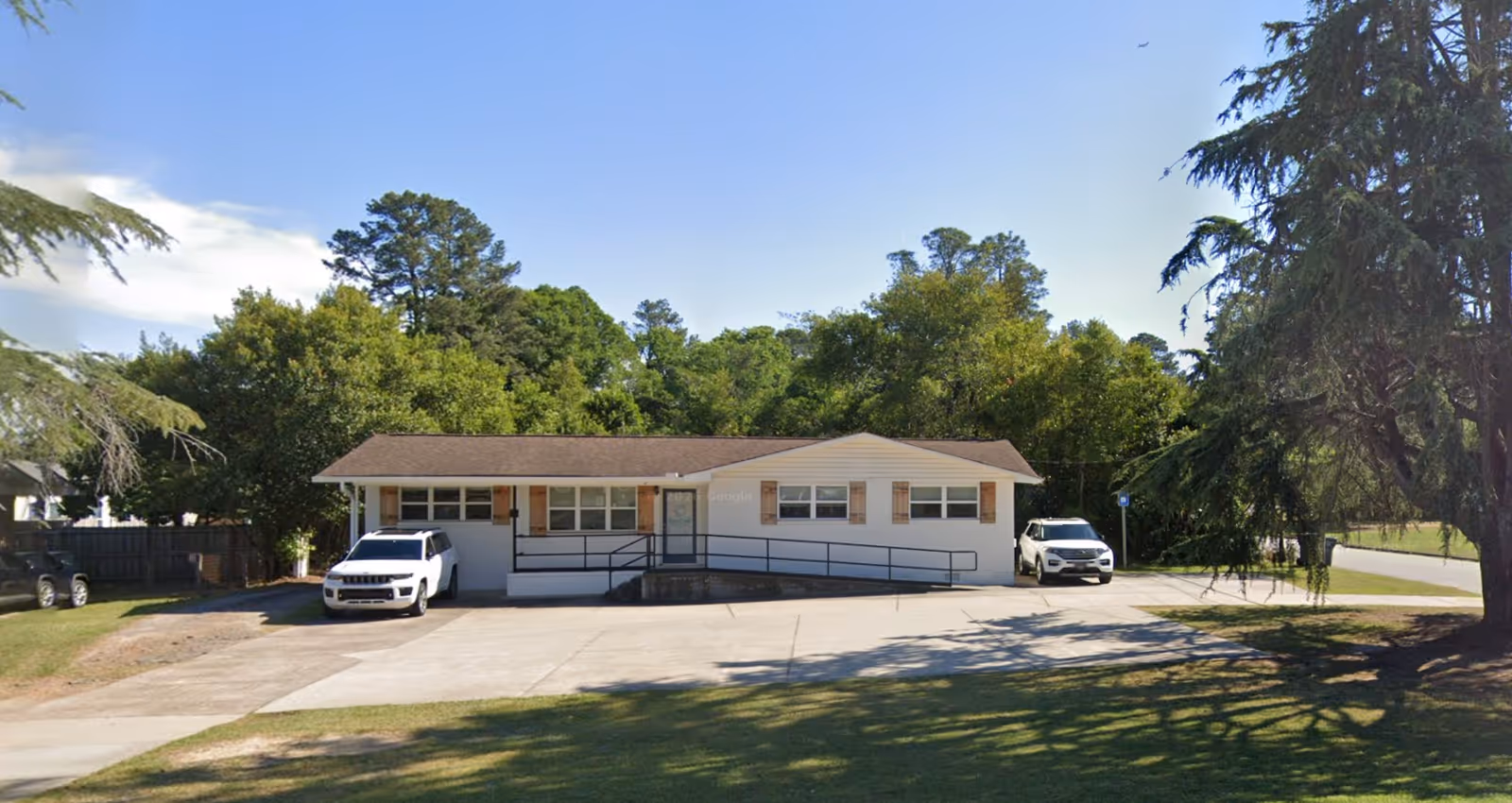 Front view of Lenus In Home Care facility with parked cars.