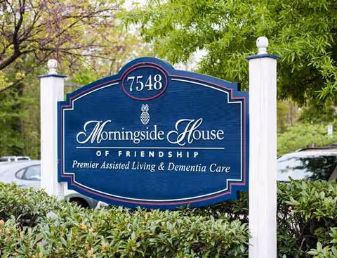A blue Morningside House sign with a pineapple emblem and white posts at a landscaped entrance.