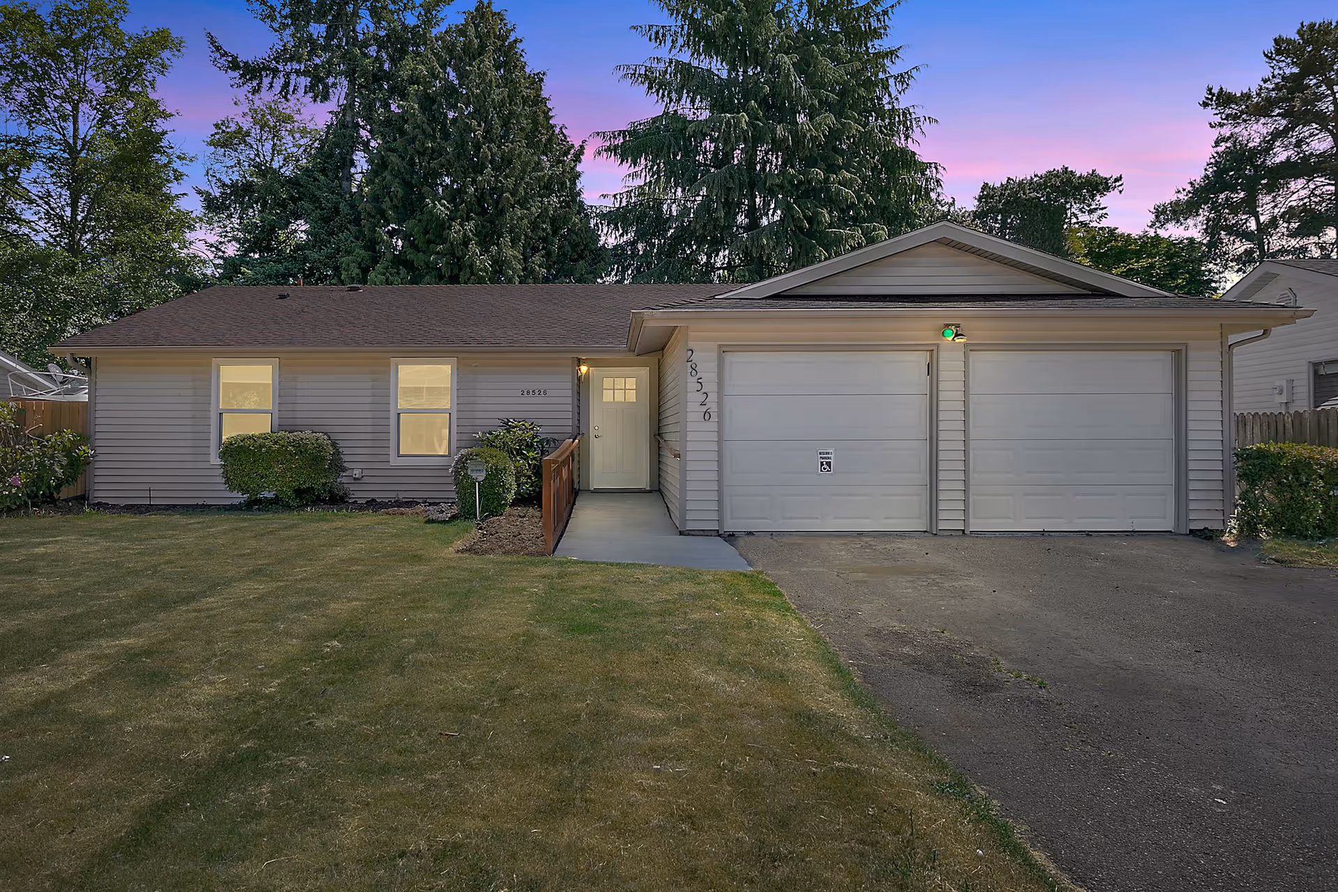 Single-story home with a two-car garage, front yard, and entry pathway.