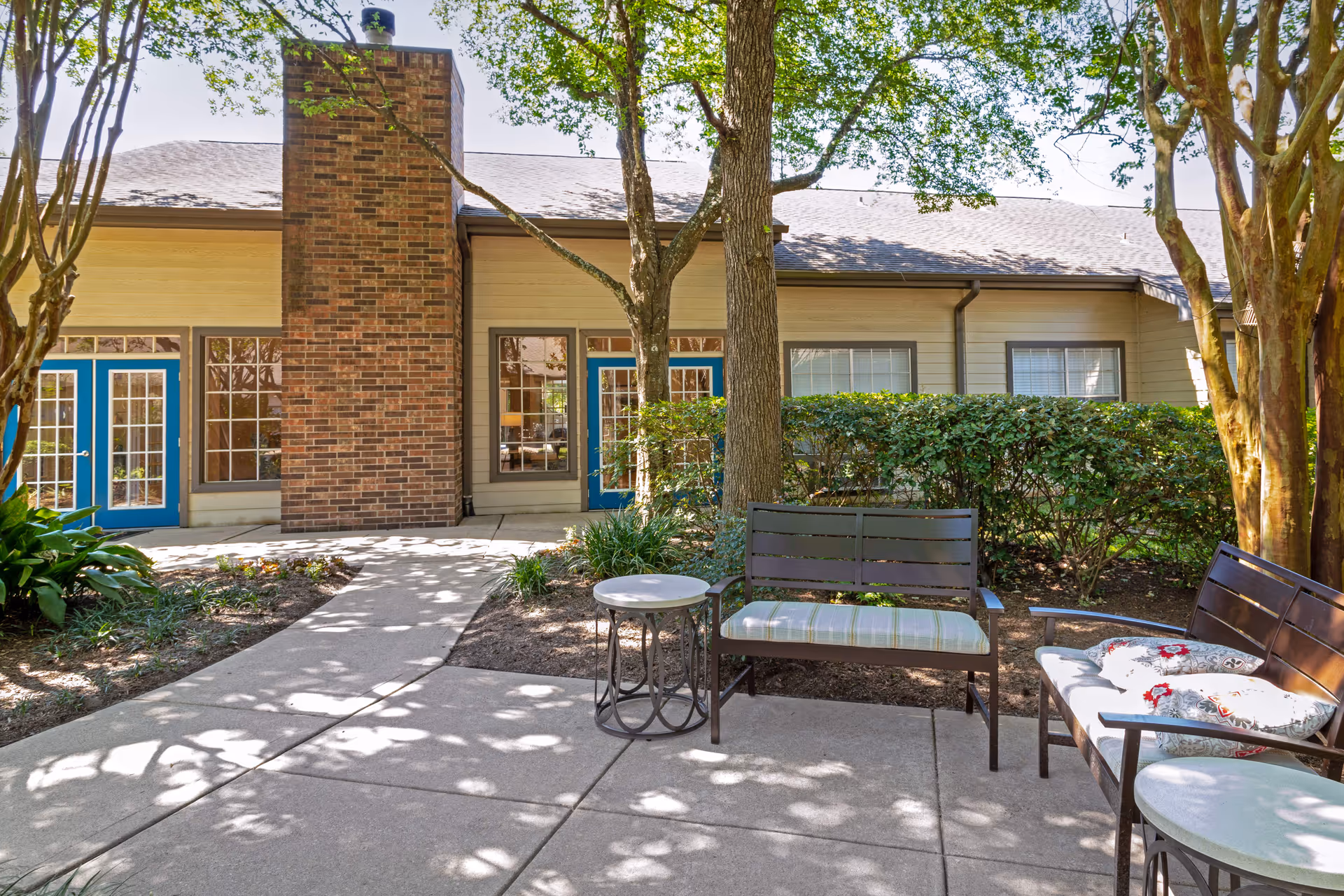 Outdoor courtyard at Lewis Park Estates Senior Living with benches and trees.