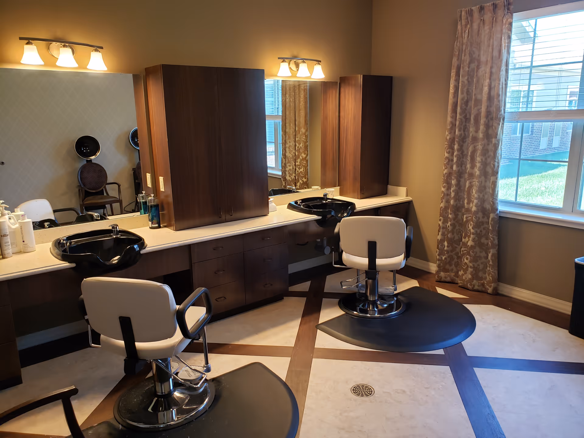 A salon area with two styling chairs, sinks, mirrors, and wooden cabinets.