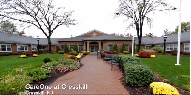 Front of a senior living facility with a brick walkway and landscaped garden.