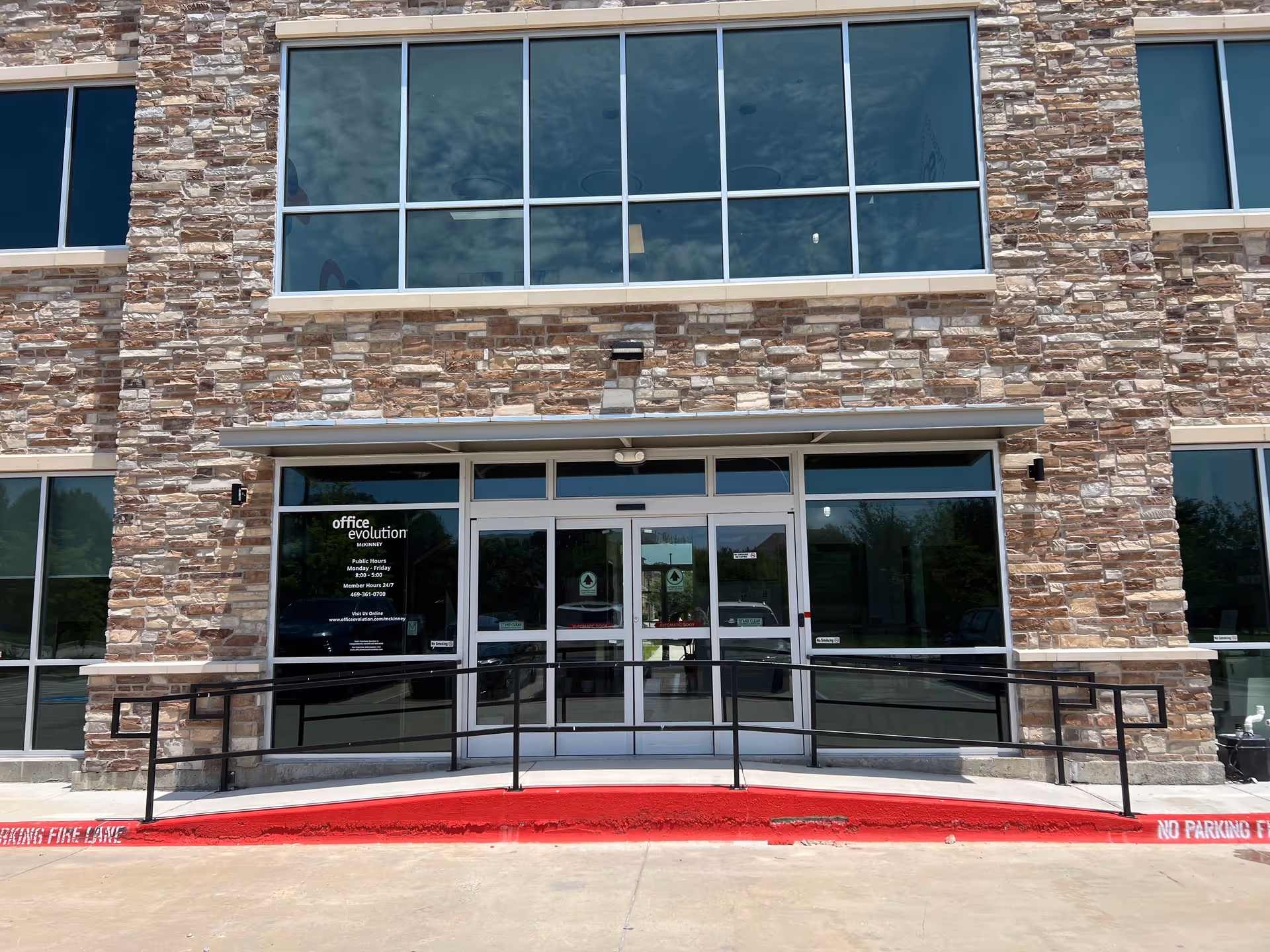 Front facade of Lone Star Health Help LLC, glass entrance, stone walls, accessible ramp.