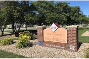 A brick sign reading Southdale Towers sits in a landscaped, tree-filled front yard.