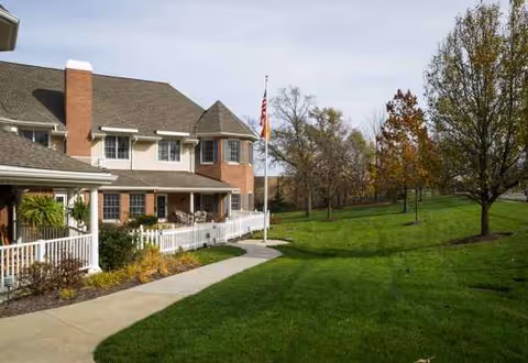 Exterior view of Bickford of Rocky River with a lawn, walkway, and flagpole.