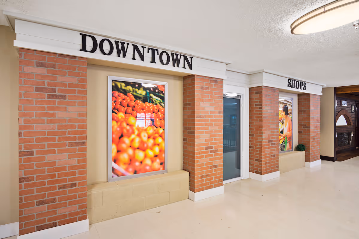 Indoor corridor with brick columns and storefronts labeled Downtown and Shops.