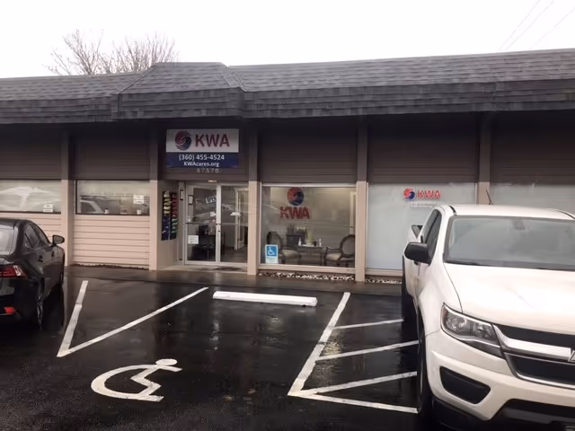 Exterior view of a KWA In-Home Care storefront with parking and accessibility signs.