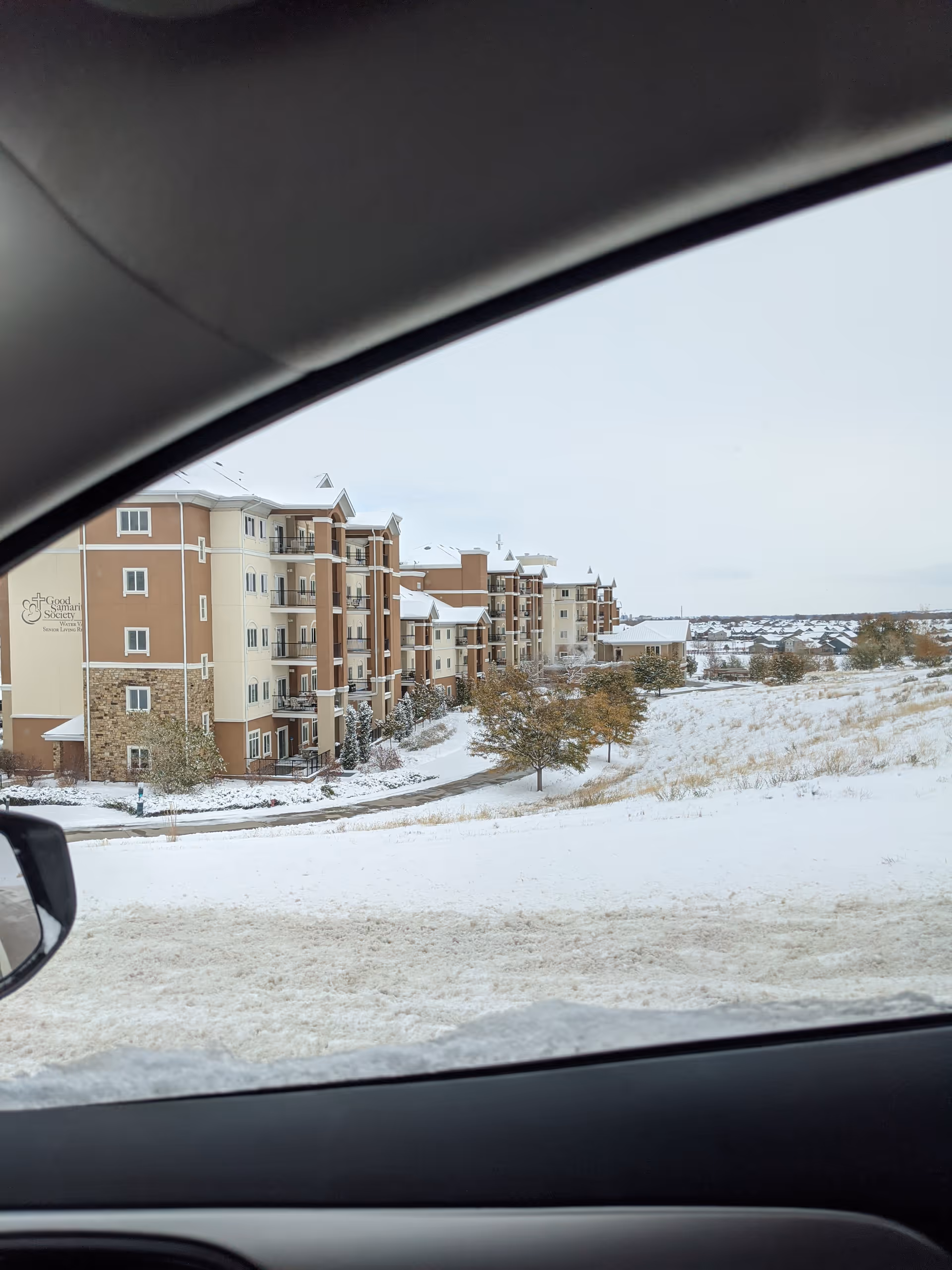 Snowy exterior view of Good Samaritan Water Valley Resort buildings from a car window.