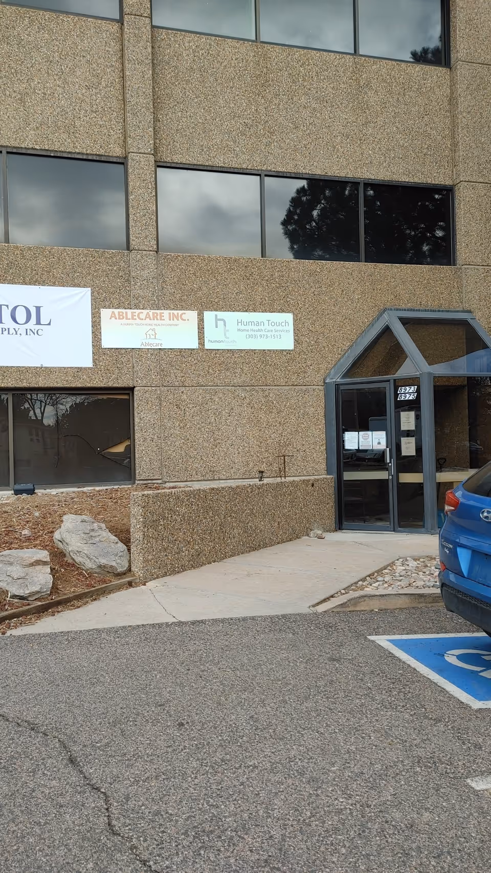 Front exterior of a concrete building with signage and an entry door.