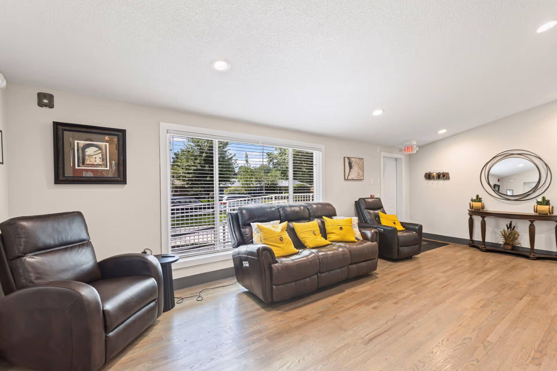 Leather recliners and sofa arranged in a bright communal living room.