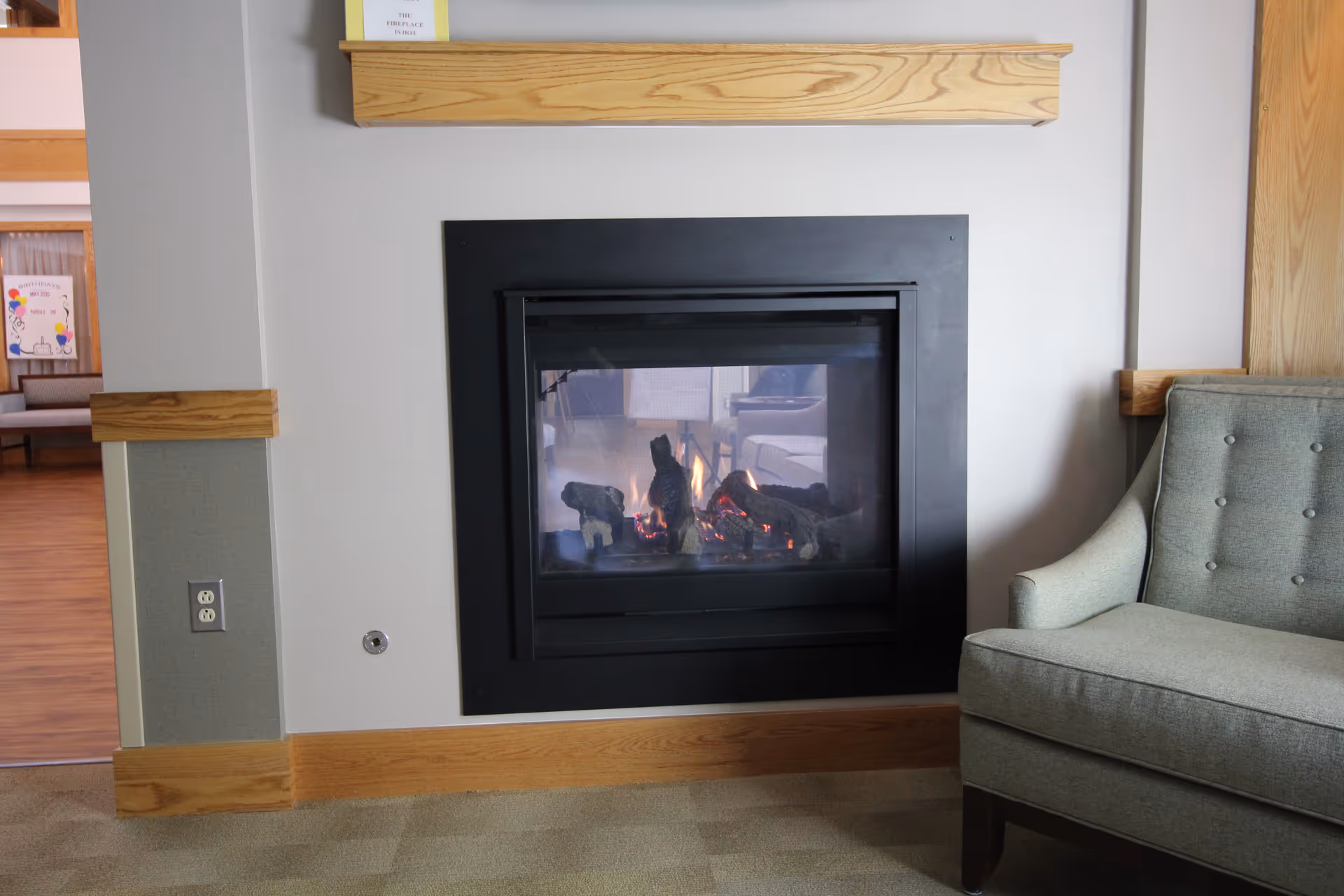 Cozy interior living area with a modern fireplace and upholstered chair.