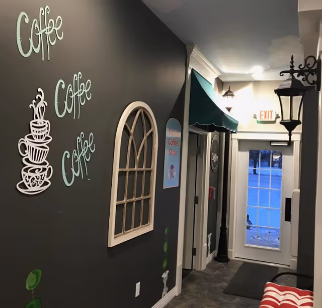 Interior corridor with coffee shop decor, arched window, exit door, teal awning.