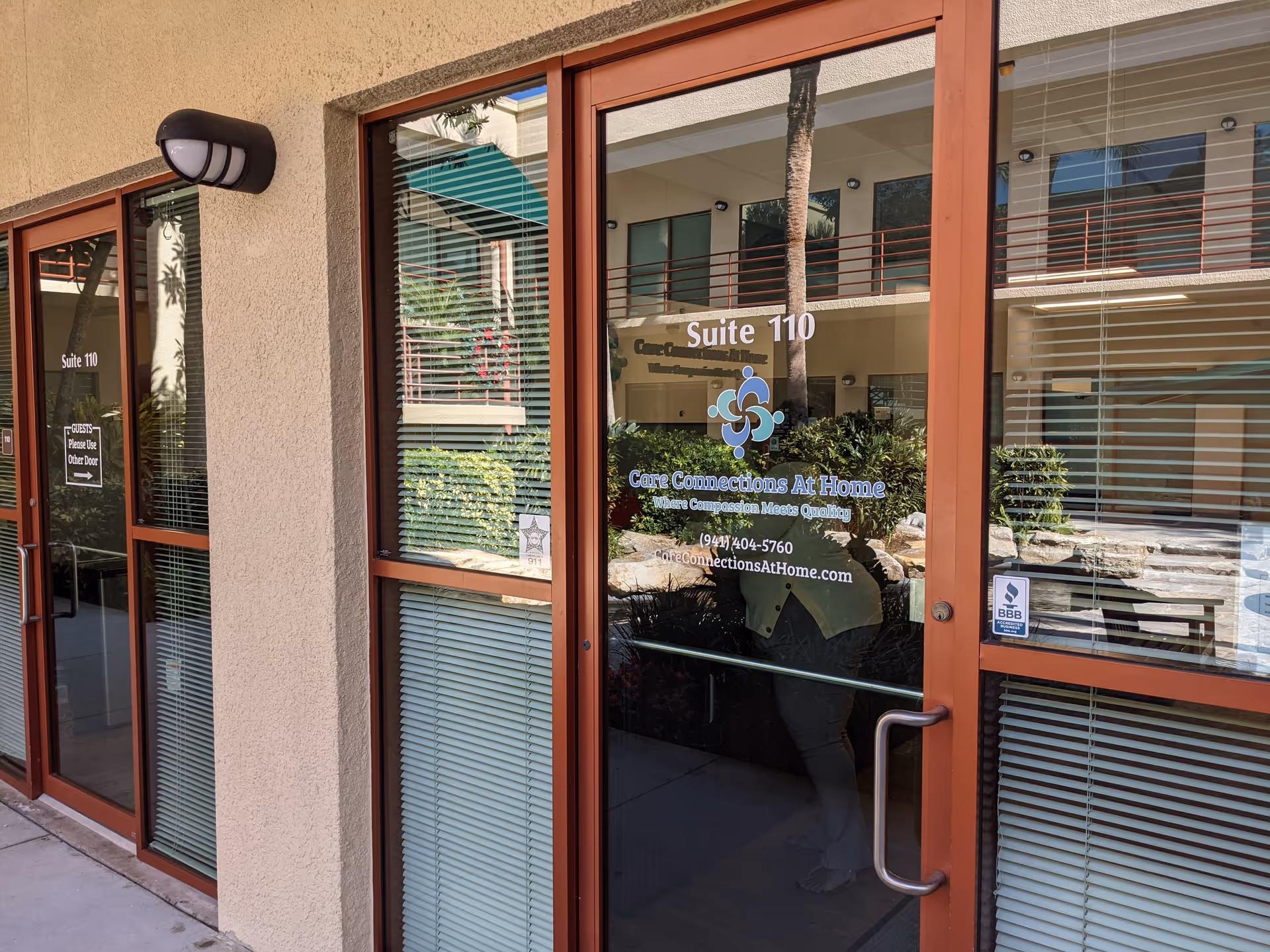 Glass entrance of Care Connections At Home with Suite 110 signage on exterior doors