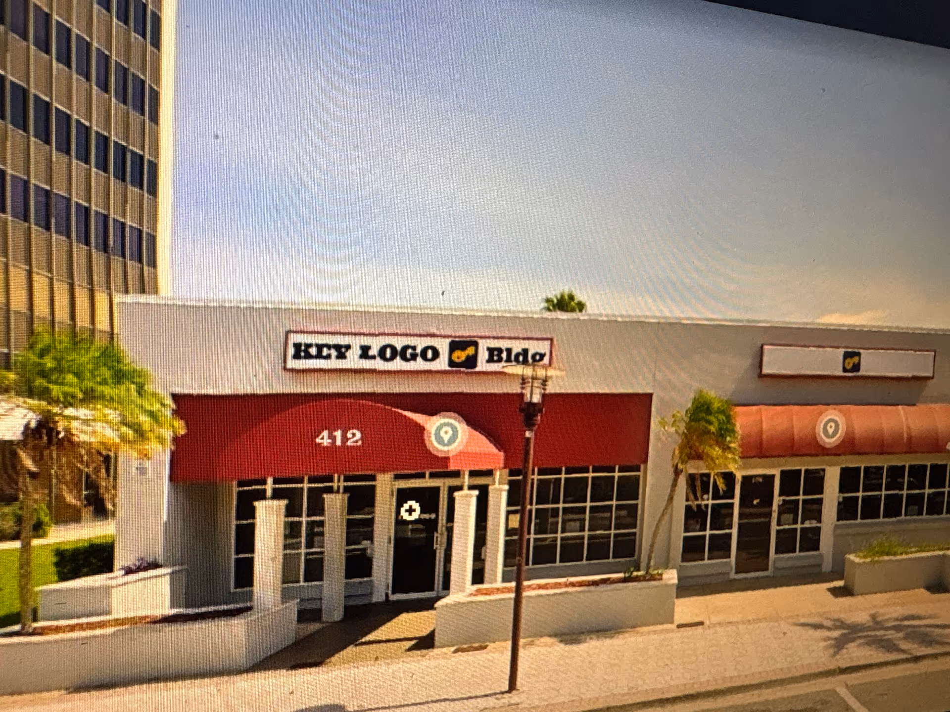 Street-level view of a storefront building with red awnings and numbered address 412.