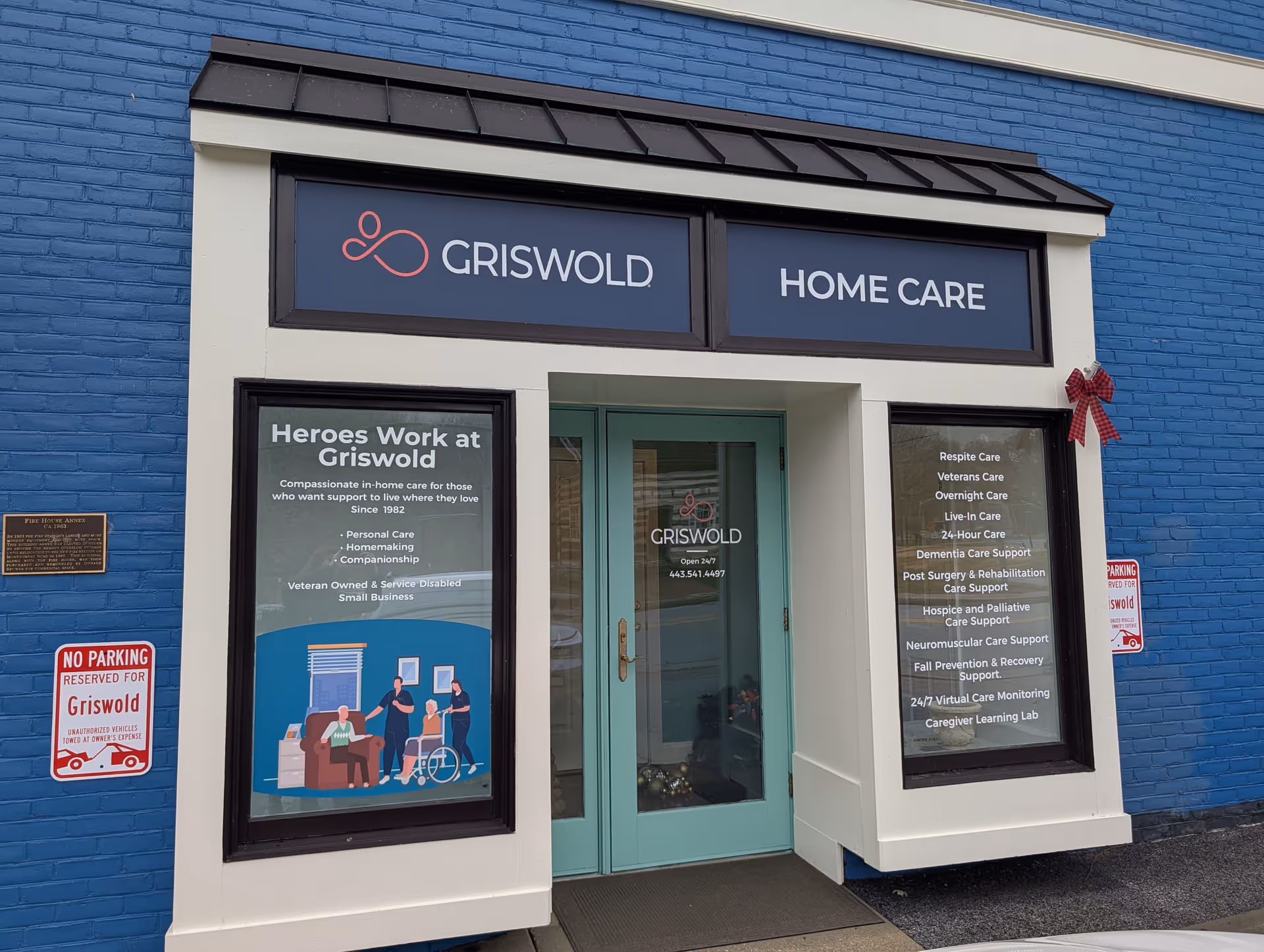 Blue brick storefront with Griswold Home Care signage and posters in windows.
