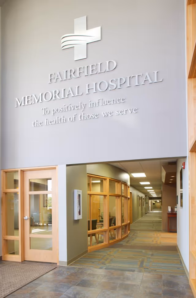 Entrance to Fairfield Memorial Hospital with sign, glass doors, and long hallway.