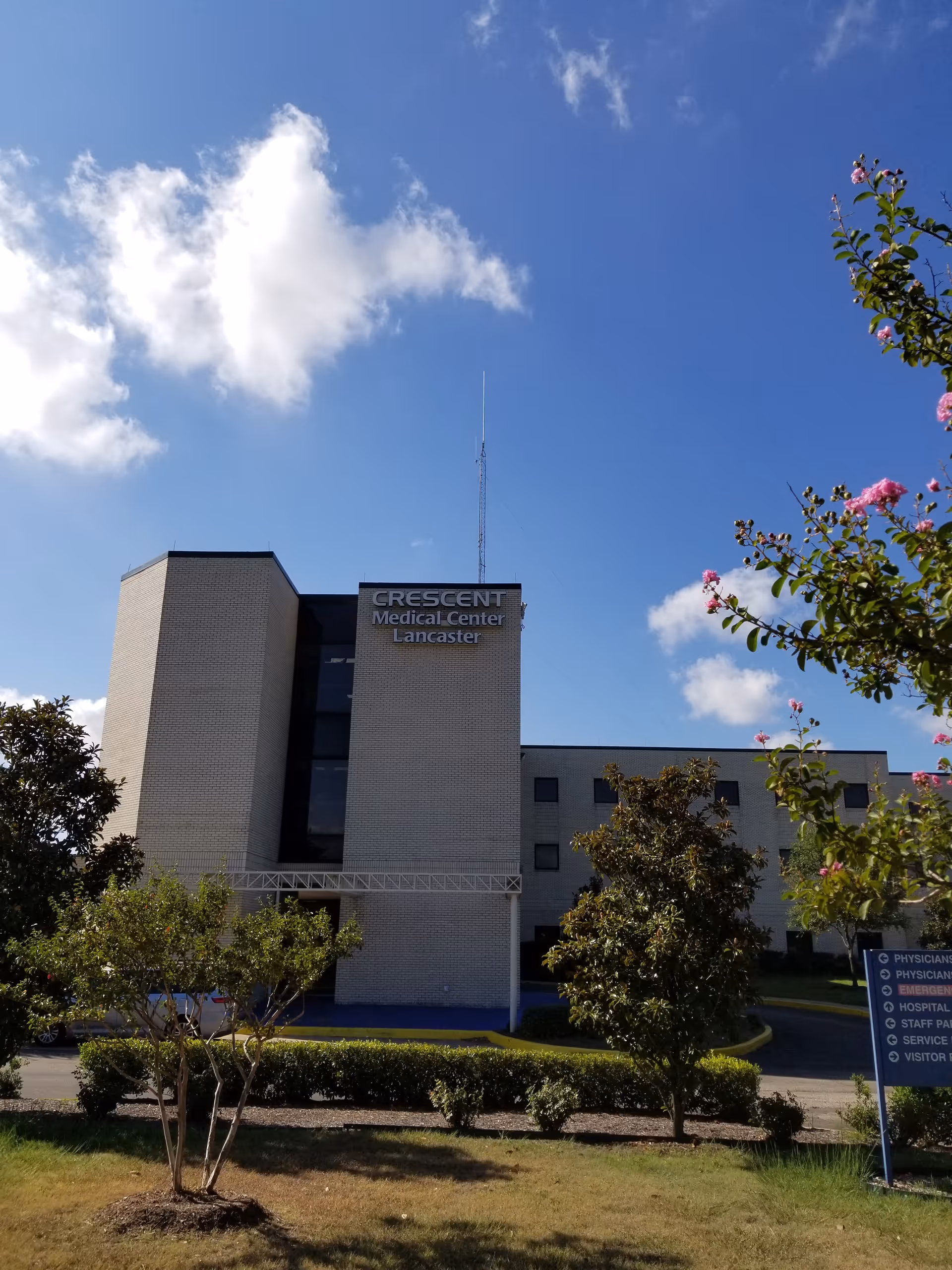 Modern medical center exterior with Crescent Medical Center Lancaster sign under blue sky.